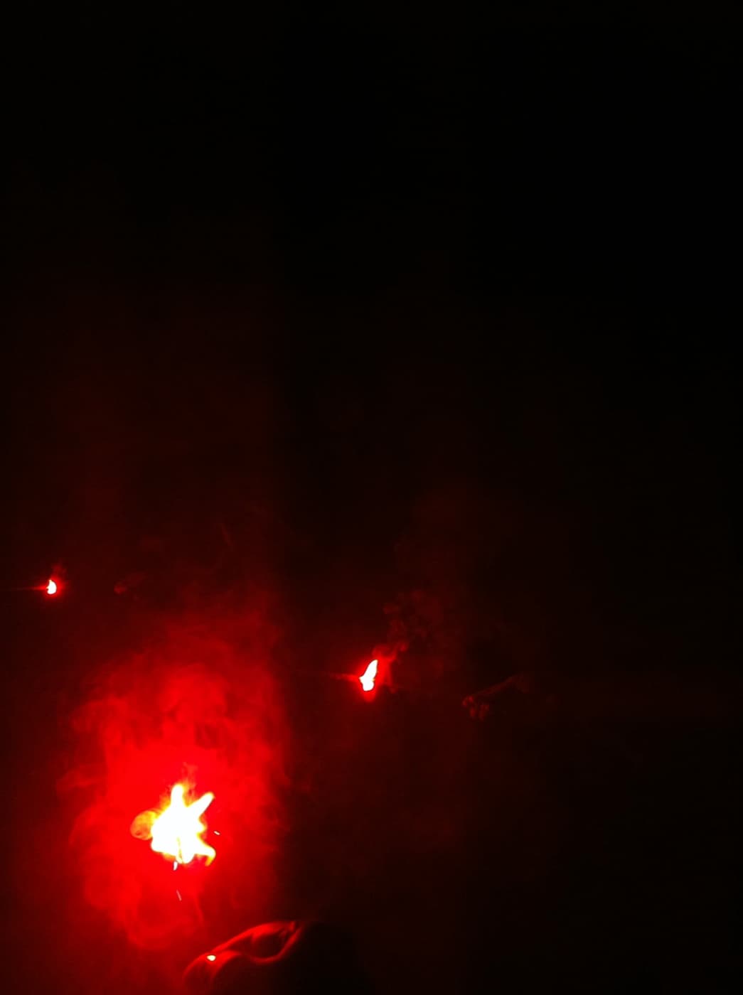 Sparks and embers glowing against deep black of night