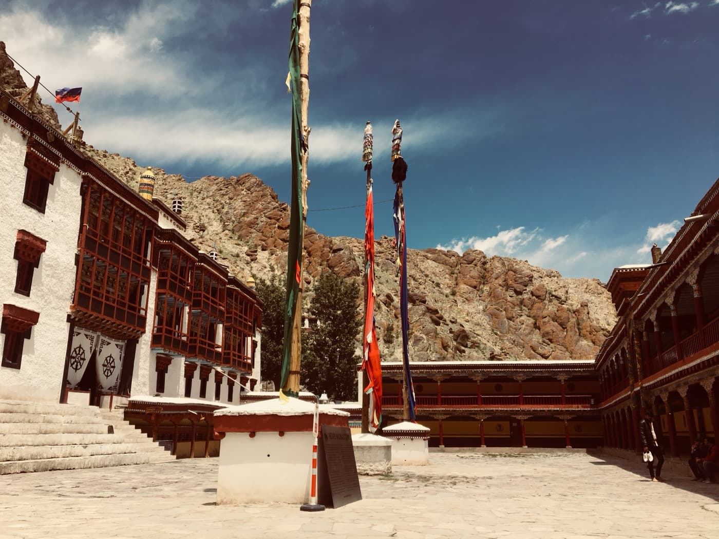 Tibetan prayer flags in a monastery courtyard set against red rock
