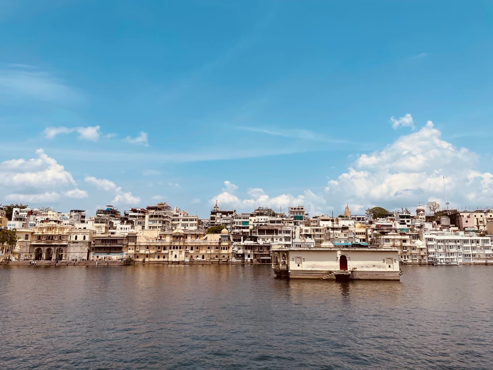 A palace reflected across the wide still water of Lake Pichola